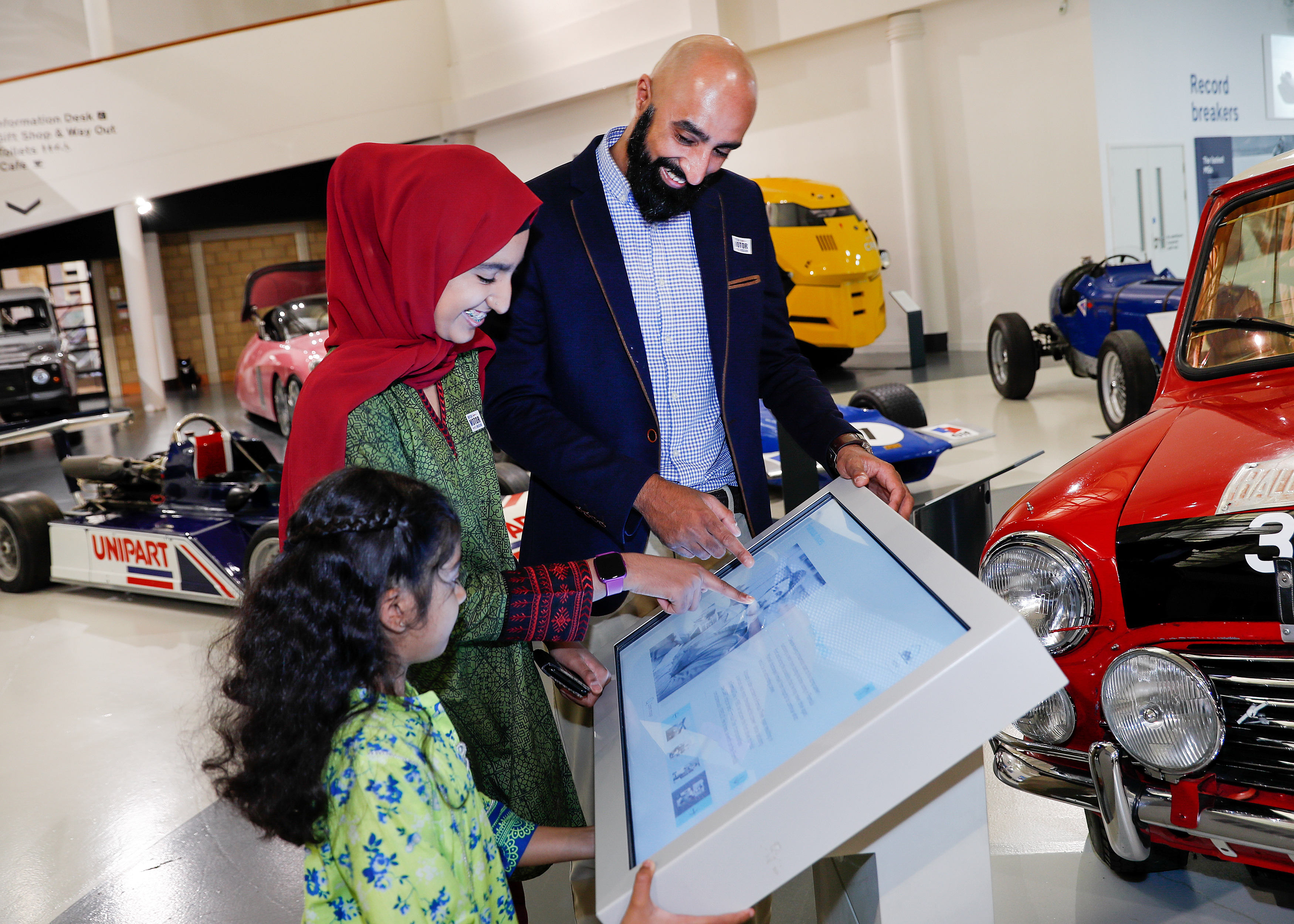 A family looking at an interactive exhibit at the British Motor Museum