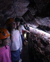 Un groupe d'enfants casqués explorant un passage souterrain