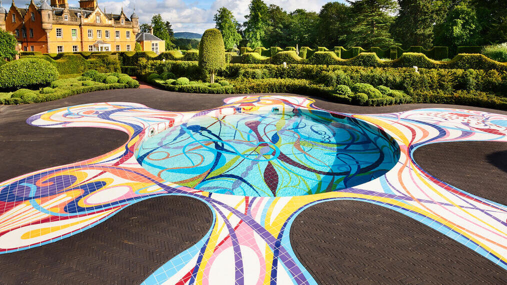 Ground pool sculpture in the landscape at Jupiter Artland with house and topiary gardens in distance