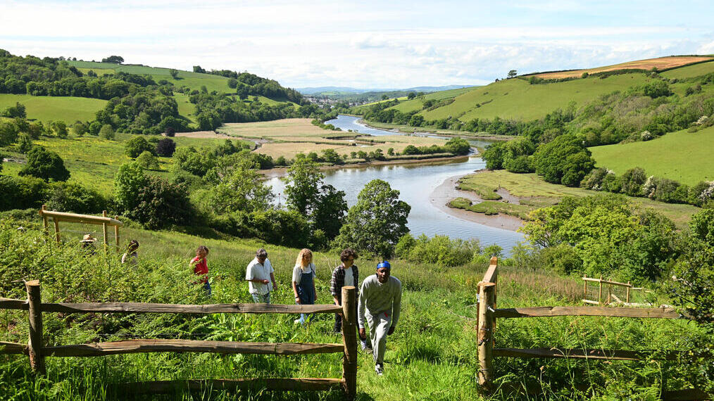 A group of people walking on a hill in the countryside