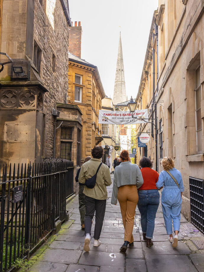 Group of friends walking on a cobbled street.