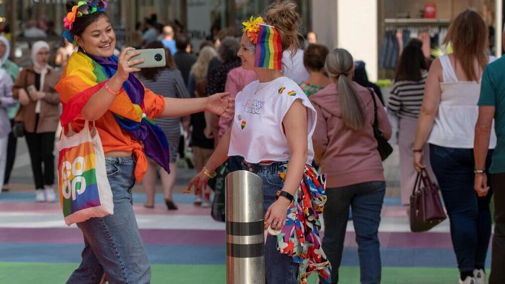 Two women dressed in Pride outfits at Victoria Gate, Leeds