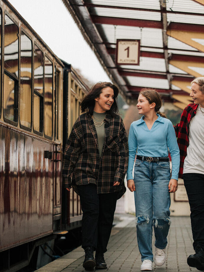 Trois personnes marchant le long d'un quai de gare.