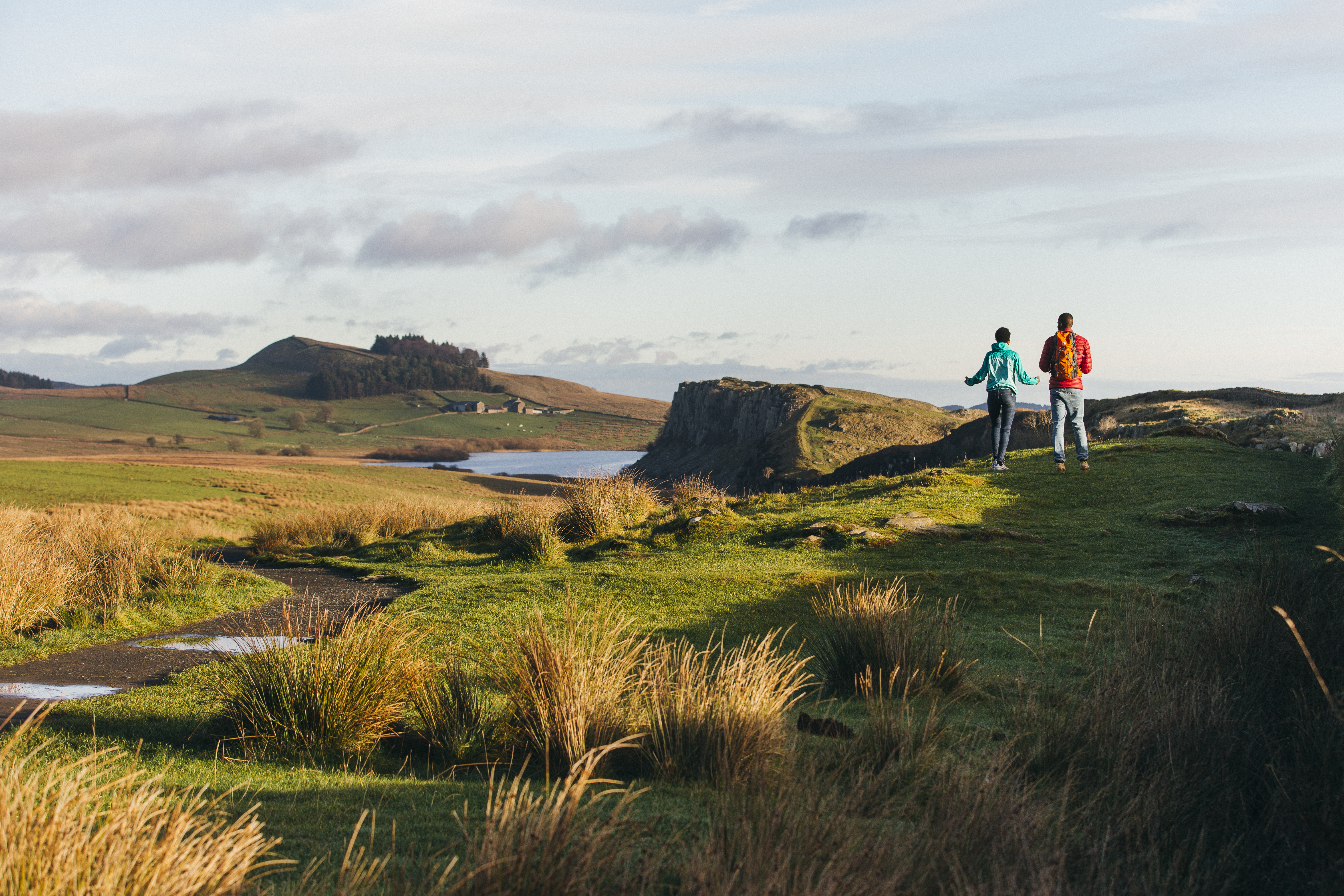 Two young adults walking the Northumberland, UK countryside.