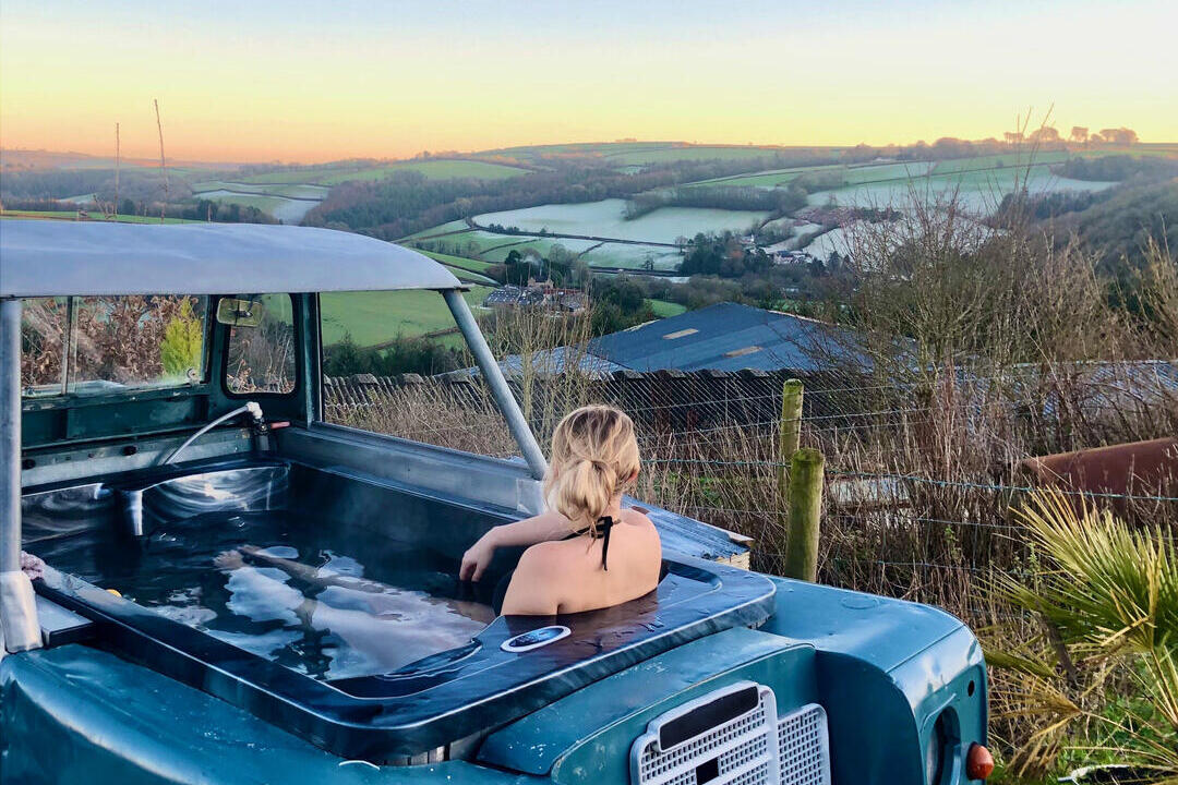 Femme dans un véhicule transformé en jacuzzi, contemplant une vallée