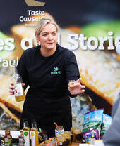 Donna presso una bancarella che offre assaggi di bevande al pubblico