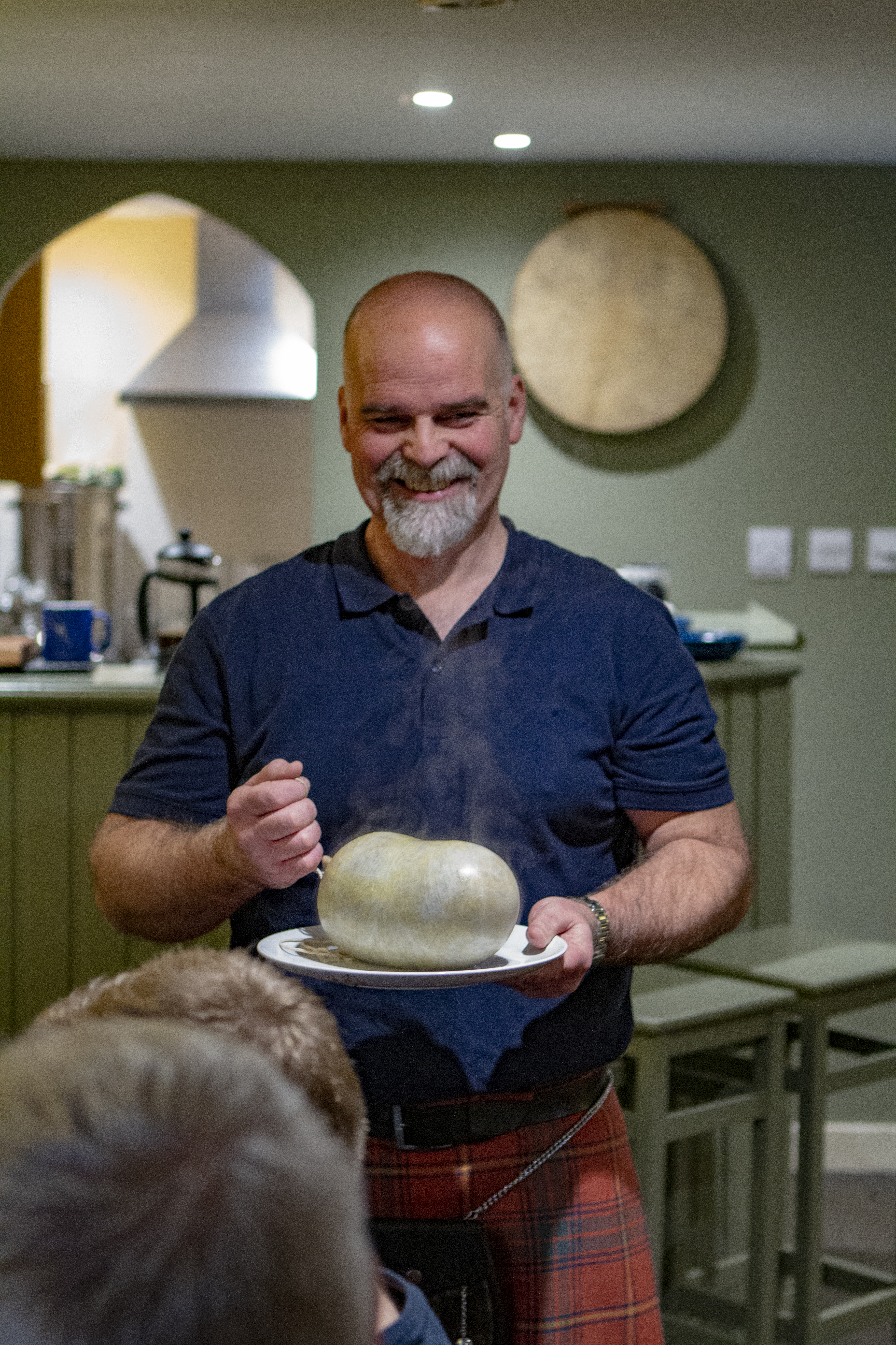 A man showing visitors how to prepare haggis.