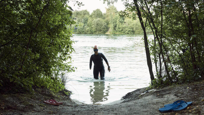 Woman in a wetsuit walking through water