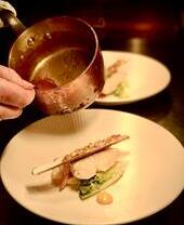 Primo piano di qualcuno che versa la salsa su un piatto