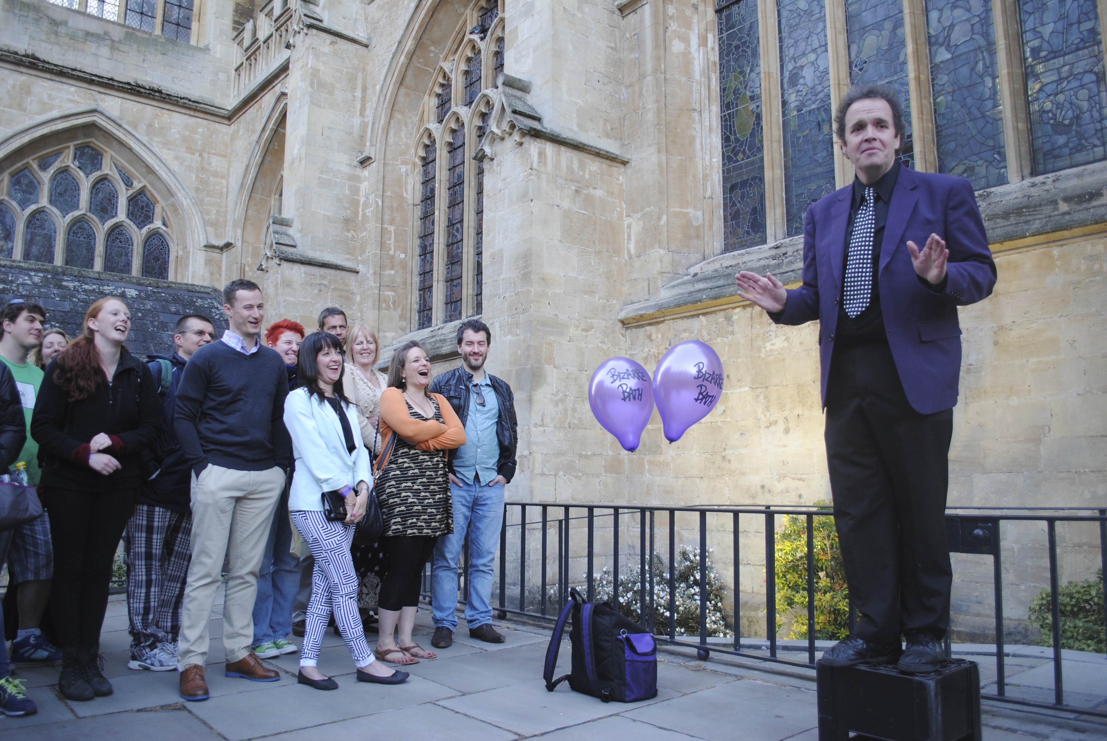A performer standing on a speaker speaking to a crowd as part of Bizarre Bath