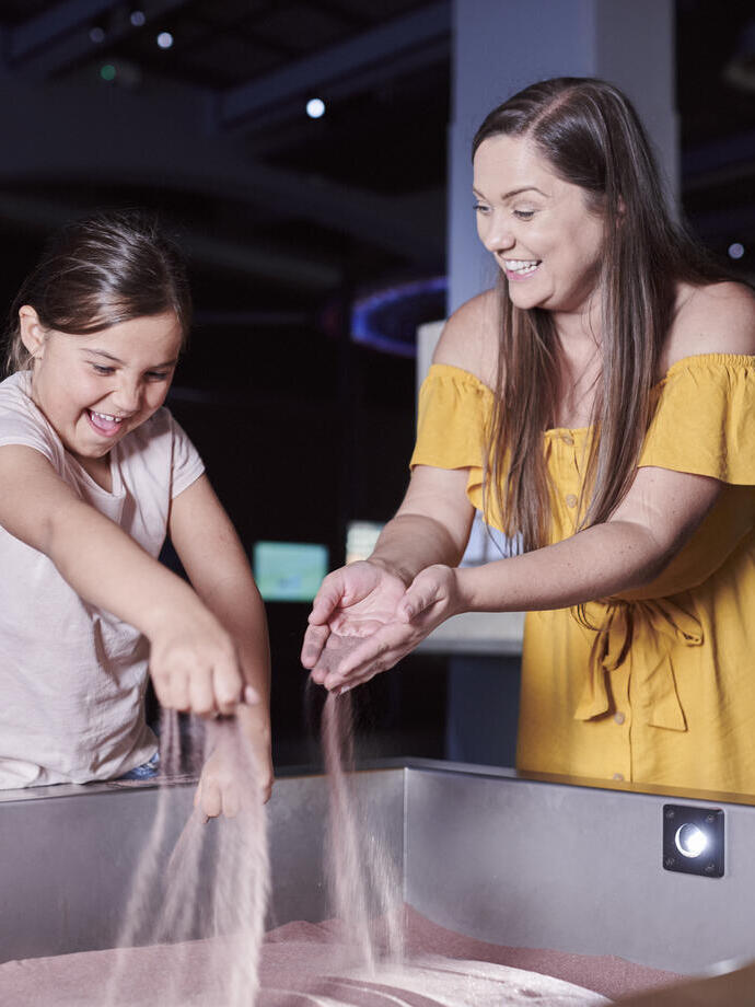 Woman and child playing an interactive display in a museum