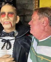 Homme observant attentivement une statue de cire représentant Dracula, dans le cadre de l'expérience Dracula