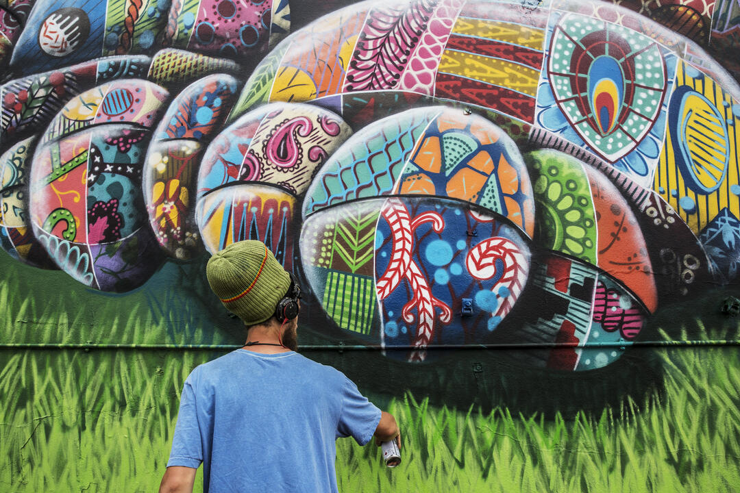 Un artiste utilisant de la peinture en spray pour créer une œuvre d'art urbain.