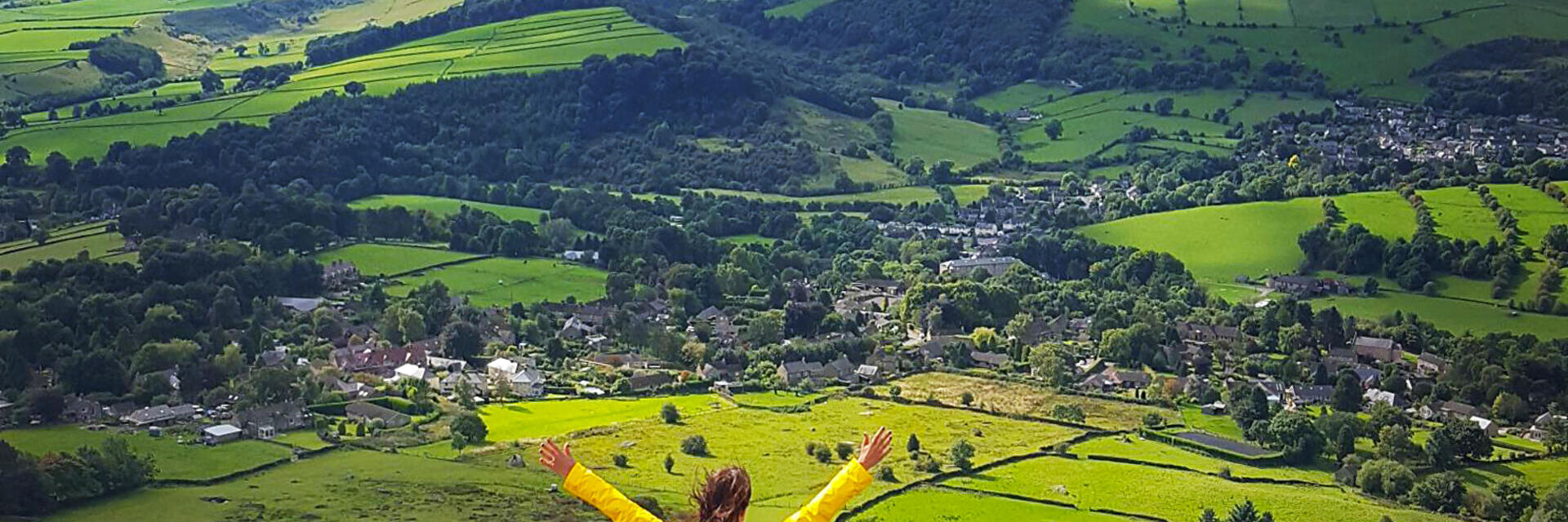 امرأة ترفع ذراعيها مستمتعة بالمنظر من أعلى