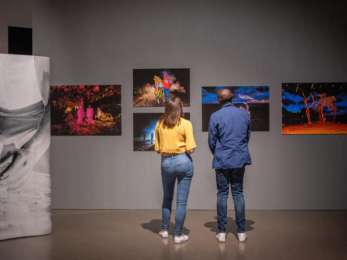 A woman and a man stand looking at an exhibition