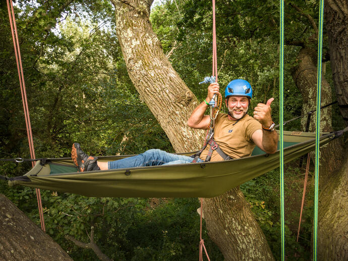 Man hanging from trees in hammock