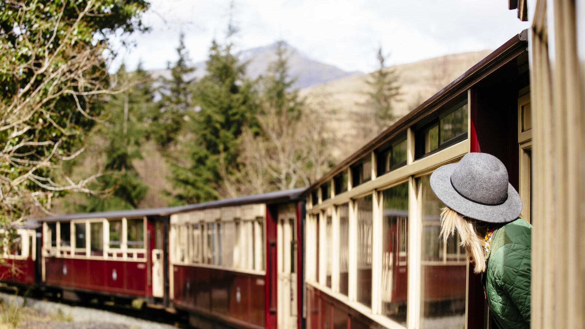 Mujer asomada a la ventana de un tren de vapor