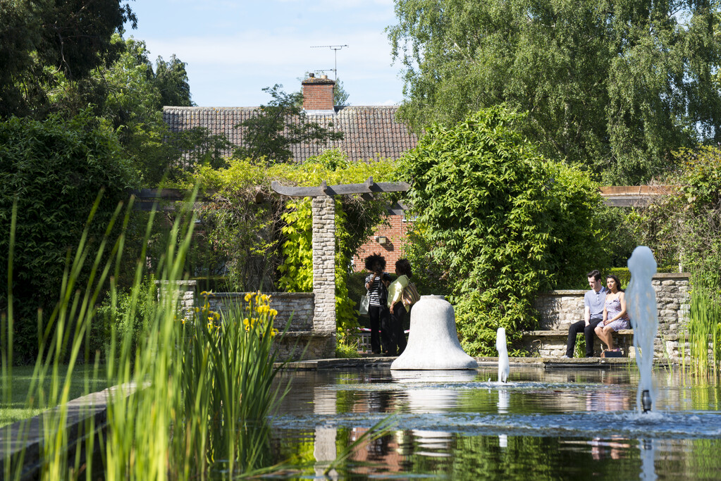 Una coppia seduta vicino a una fontana nei giardini botanici di Leicester
