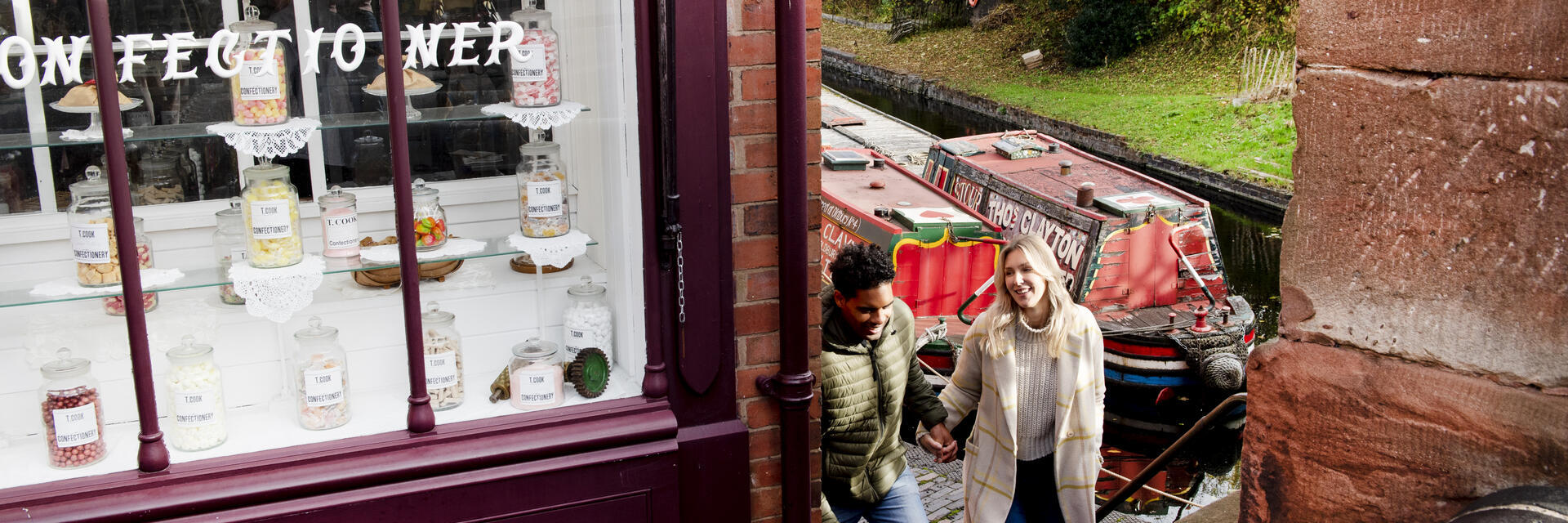 Couple walking up steps by the side of a sweet shop and canal