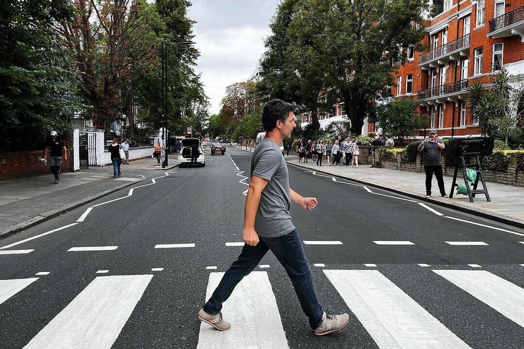 Un homme traversant la route devant les studios Abbey Road, une reconstitution de la célèbre pochette d'album des Beatles