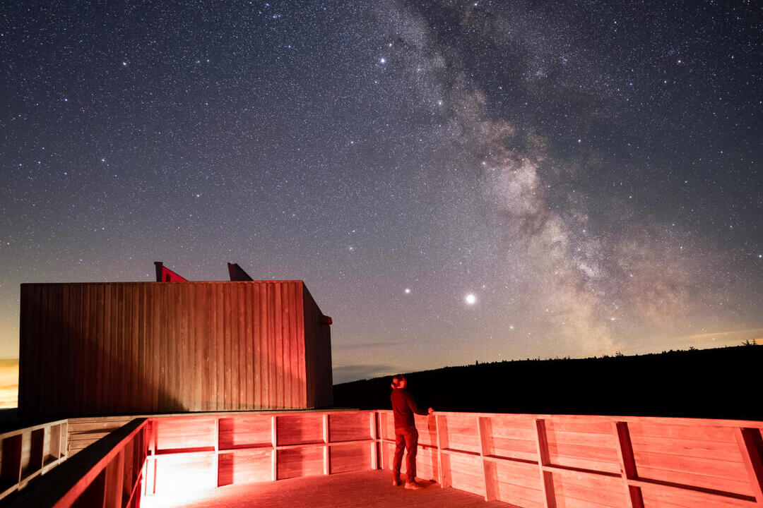 A person at the Kielder Observatory at night observing stars.