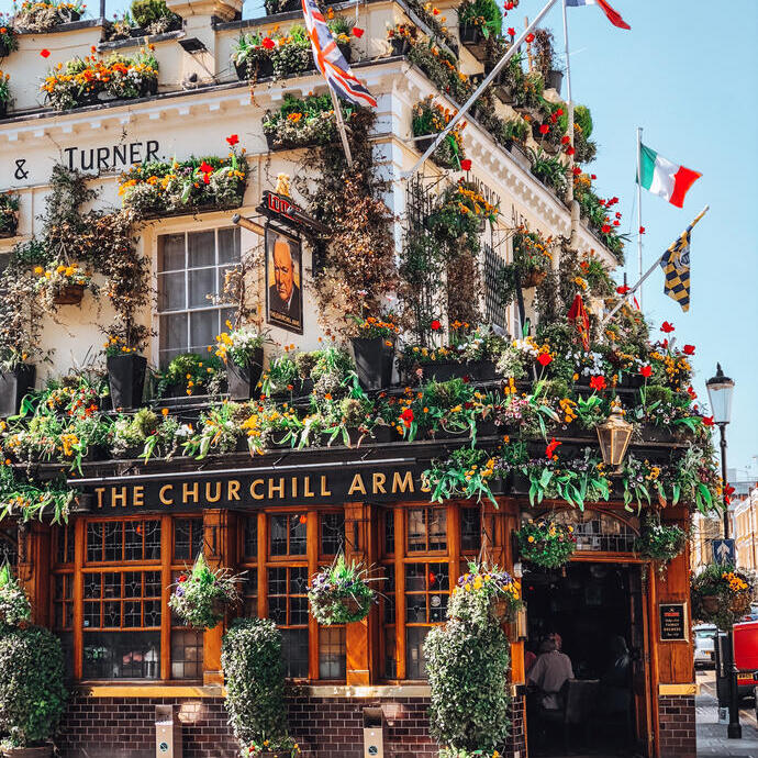 Pub decorato con bandiere e cesti fioriti appesi