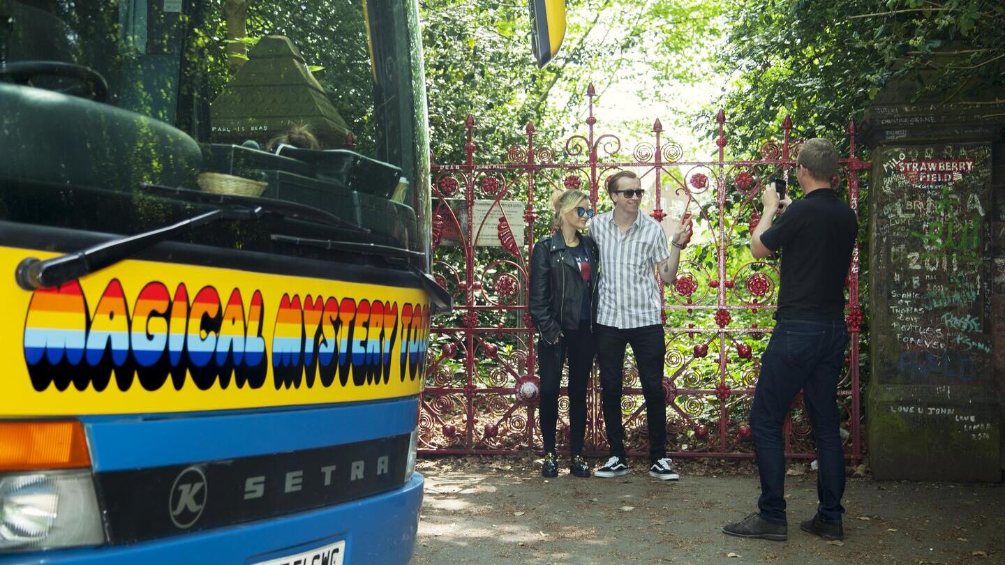 Des personnes posent pour une photo devant les portes du Magical Mystery Tour à Liverpool