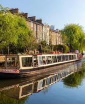 A canal boat moving down Regent's Canal in north London.