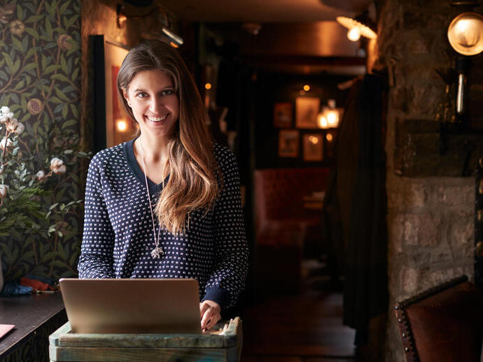 Woman working on laptop at a hotel check-in desk
