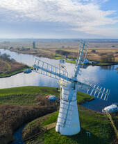 Luftaufnahme einer Windmühle und der umliegenden Weiden und Kanäle