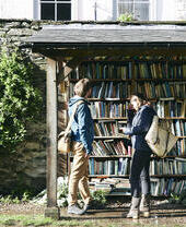 Ein Mann und eine Frau betrachten eine Auswahl an Büchern in einem Unterstand in Hay-on-Wye
