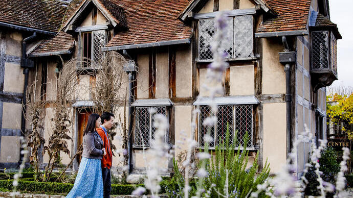 Couple walking through a garden of a Tudor building