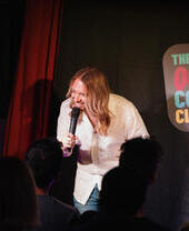 A performer on stage at the Queer Comedy Club in Archway, London