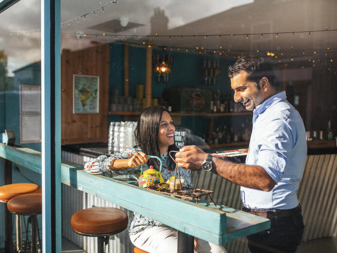 Donna a cui viene servito un drink da un membro del personale in un bar.