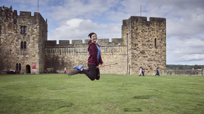 Woman on a broomstick outside a castle