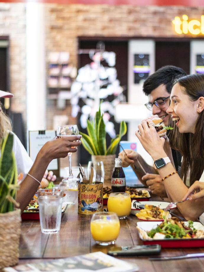 Un groupe de personnes assises sur un banc en train de manger au Storyhouse à Chester