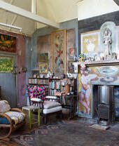 Interior of historic house with paintings on walls and decorated fireplace