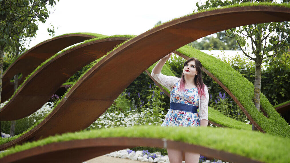 Femme regardant une sculpture en herbe