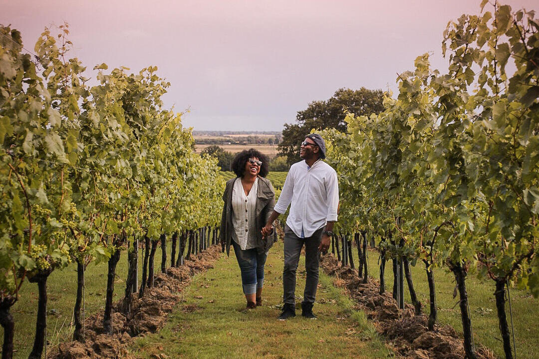 Man and woman walking between rows of vines at a vineyard