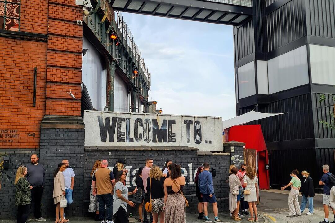 Außenansicht einer Food Hall im Industrial-Stil unter freiem Himmel.