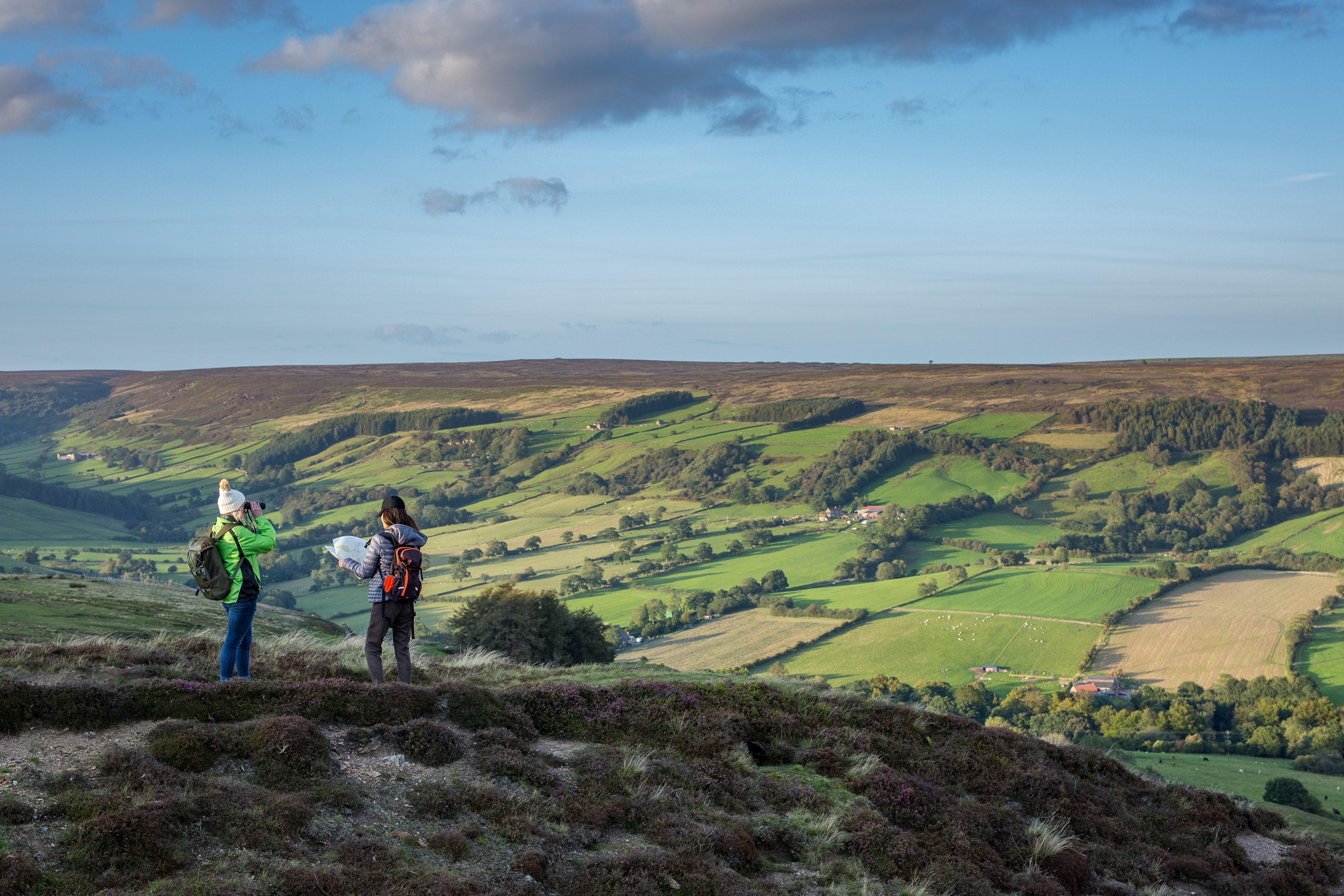 Two women checking the map on a hillside