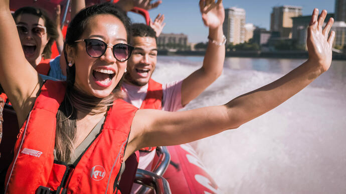 Close up of man young woman and man riding on speed boat on the Thames