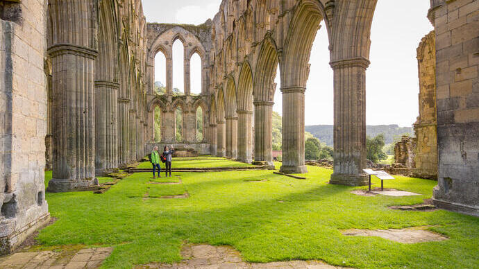 Deux amies dans la nef centrale d'une abbaye en ruines sous le soleil