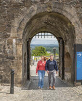 A couple exploring the grounds of a medieval castle.