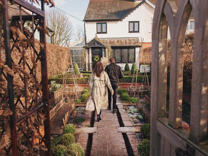 Man and woman walking towards a house