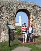 Due persone in piedi fuori dalla cappella di Hunstanton con il faro sullo sfondo