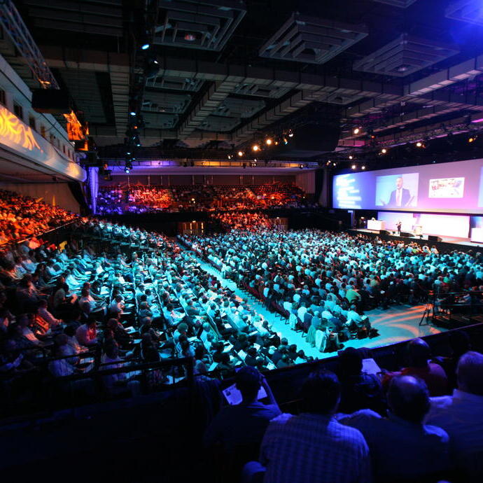 Group of people sitting in an auditorium during a presentation