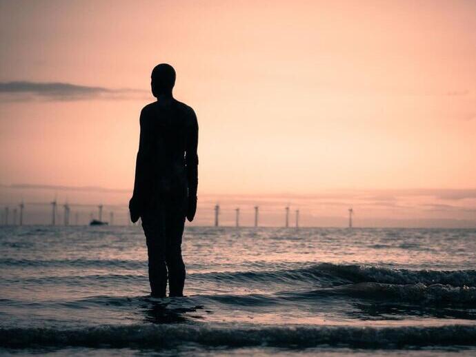 A statue on the beach at high tide