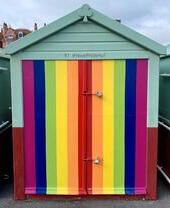 A rainbow coloured beach hut on Brighton and Hove beach
