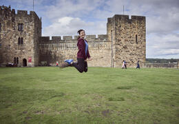 Woman on a broomstick outside a castle